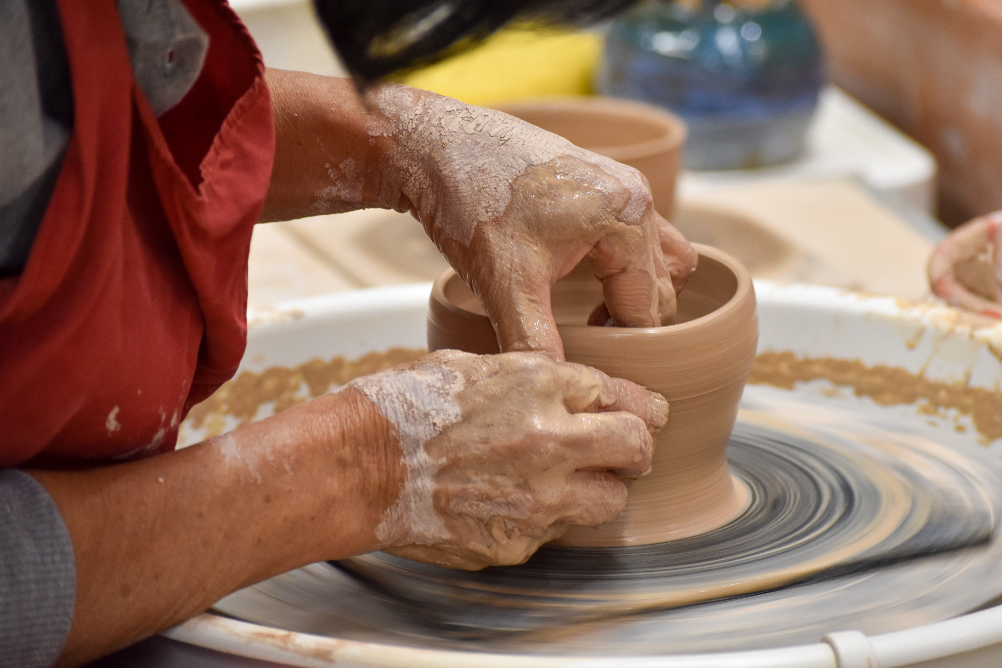 A member of de Sousa's studio throws a bowl on a wheel 